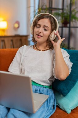 Kablosuz kulaklıklı mutlu, gevşemiş Kafkas genç kadın evinde oturuyor ve dizüstü bilgisayar ağı üzerinde çalışırken disko müziği dinliyor. Kız kıza hafta sonu aktiviteleri. Dikey