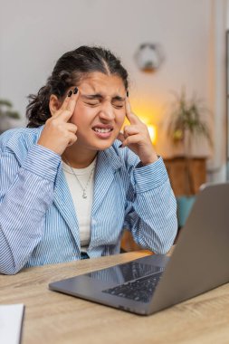 Baş ağrısı, gerginlik ve ofis masasında migren stresi çeken yorgun Hintli kadın. Dizüstü bilgisayar ağı üzerinde çalışan oldukça serbest çalışan bir broker kızı. Çok çalışıyorum. Dikey.