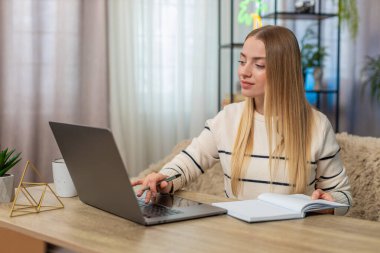 Beyaz bir kadın evinde oturmuş dizüstü bilgisayarında daktilo yazıyor, gülümsüyor, uzaktan eğitim alıyor, not defteri açık, tamamen ilham dolu. Kız mutlu görünüyor, motive olmuş, yeni fikirler keşfediyor, internette çalışmaya devam ediyor.