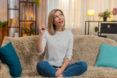 Orta yaşlı bir kadın evdeki kanepeye oturur ve şaşkınlıkla gözlerini açar. Aniden bir soruna çözüm bulur. Yetişkin kadın neşe ve berraklıkla tepki verir, ilham ve zihinsel başarı kıvılcımı hisseder..