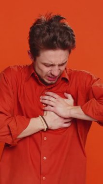 Stresli, hasta, hasta, beyaz bir adam göğsünde kalp krizi geçirerek kalp krizi geçirerek kalp krizi geçirerek, kalp krizi belirtileri göstererek, kendini kötü hissederek, kapalı alanda izole edilmiş genç bir adam.