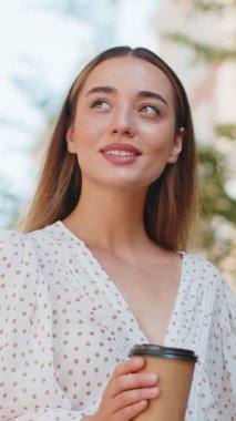 Kafkasyalı genç ve güzel bir kadın sabah kahvesinin tadını çıkarıyor sıcak bir şeyler içiyor ve dışarıda gülümsüyor. Dinleniyorum, ara veriyorum. Şehir merkezindeki caddede durmuş, kahve içen bir kız. Kasaba yaşam tarzları.