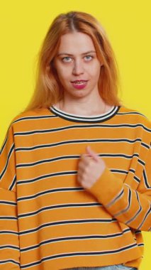 Gözüm üzerinde. Özenli, beyaz, genç, sarışın bir kadın gözlerini ve kamerasını işaret ediyor. Seni birini gözetlerken izlediğimi göster. Sarı arka planda izole edilmiş katı yetişkin kız.