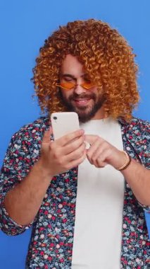 Mutlu genç adam akıllı telefon daktilo kullanarak 