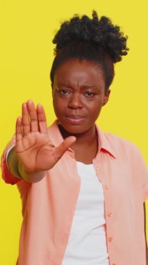 Dur, yeter. Siyahi bir kadın el ele tutuşmak yok diyor. Bitiş çizgisinde el ele tutuşmak yok. Bitiş uyarısı, yasak erişim, iletişim, vücut dili, tehlike. Sarı arka plandaki kız