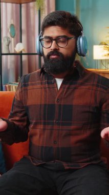 Kulaklıkla müzik dinleyen Hintli bir adam, derin derin nefes alıyor, gözleri kapalı konsantre düşüncelerle meditasyon yapıyor, huzurlu bir zihin. İspanyol adam dinleniyor. Oturma odasındaki kanepede oturuyor..