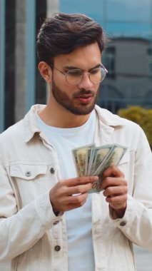 Mutlu genç Hintli adam paraları nakit olarak sayıyor banknotları tutuyor, faturaları ödüyor maaşları hesaplıyor açık havada rüşvet veriyor. Şehir merkezinde başarılı bir zengin Arap Hindu adam. İş adamları