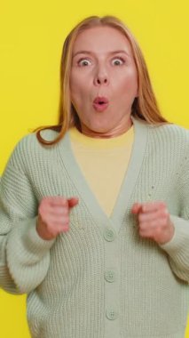 Aman Tanrım, vay canına. Heyecanlı kazanan kadın şaşkınlıkla el kaldırıyor kameraya büyük gözlerle bakıyor başarıyı kutlayan zaferin şokuyla iyi haberleri kutluyor. Sarı arka plandaki kız