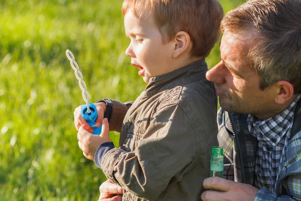 Baba ve oğul bubblesat parkta oyun gün süresi.