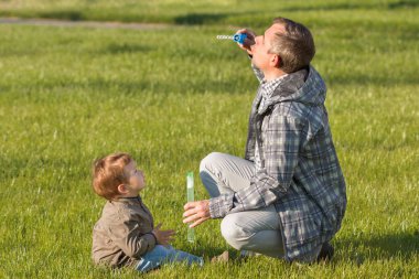 Baba oğul sabun köpüğü yapmak gösterir.