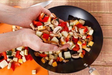 kesme tahtası üzerinde taze sebze wok içinde düşer. pişirme kavramı.