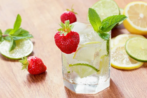 Un vaso de agua fría con limón y lima, cubitos de hielo y hojas de menta — Foto de Stock