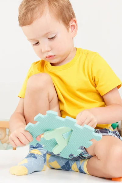 Happy preschool child learning to read playing with colorful alphabet letters.