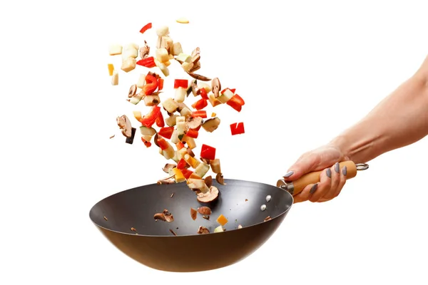 Taze sebzeler tavaya uçuyor, beyaz arka planda izole edilmiş.