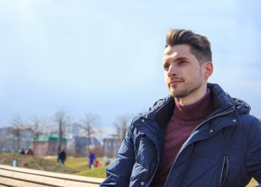 Genç bir adam bir bankta oturuyor