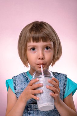 Küçük kız milkshake, pembe arka plan içecekler.