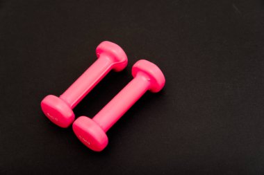 pembe dambıl güzel bir vücut için sağlıklı bir yaşam tarzı kilo ve siyah bir arka planda doğru yeme alışkanlıkları ve diyet yetiştirmek için bir spor rakam var