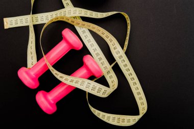 pembe dambıl güzel bir vücut için sağlıklı bir yaşam tarzı kilo ve siyah bir arka planda doğru yeme alışkanlıkları ve diyet yetiştirmek için bir spor rakam var