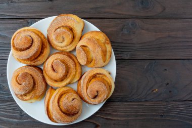Beyaz tabakta taze pişmiş tarçınlı çörekler..