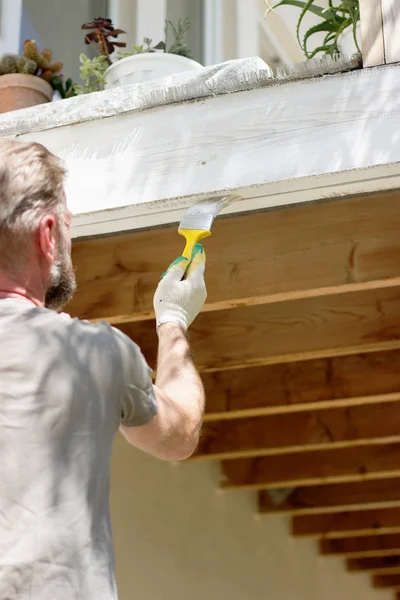 Painting woodwork outside.