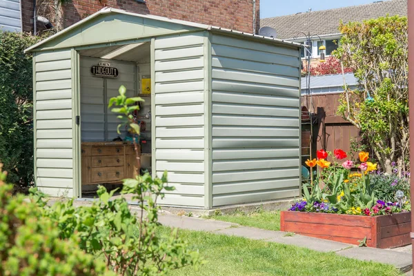 A modern shed and breautiful grden with blooming flowers and a D Stock Photo