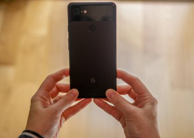 Elinde bir google piksel 3 telefon tutan bir kadının bir atış sh