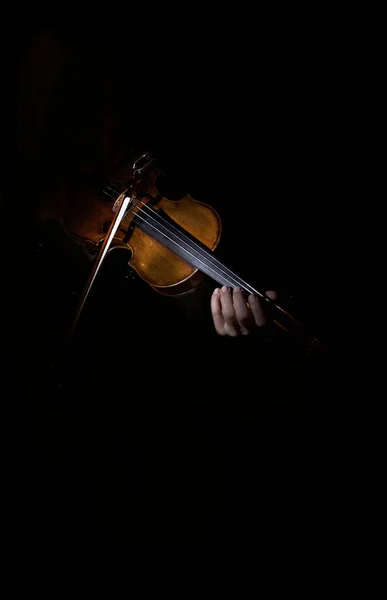 Artistic photo of violinist playing the violin , isolated in dark background, only violin.Close-up of musician playing violin.