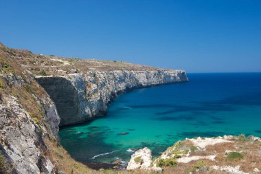 Malta kıyılarında kayalıklar, Malta adasında deniz üzerinde altın kayalar açık mavi gökyüzü arka planıyla, Malta, Malta 'da güzel bir koy, Malta doğası, Bahrija
