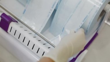 Laboratuar asistanı sterilizasyon için cerrahi alet üstünde belgili tanımlık makine paketleri.