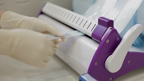 Лаборант упаковывает хирургический инструмент и закрывает — стоковое видео