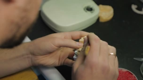 Un técnico dental trabaja con un modelo de la mandíbula — Vídeo de stock