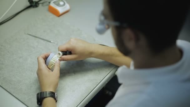 Tehnicianul dentar macină coroana cu o mașină de rectificat — Videoclip de stoc