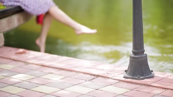 Flickan stänckar hennes fötter i vattnet. — Stockvideo