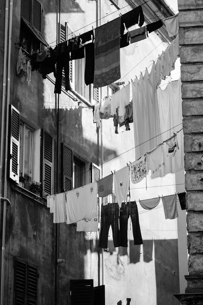 İtalya 'nın kuru, dar sokaklarında asılı giysiler, siyah ve beyaz 
