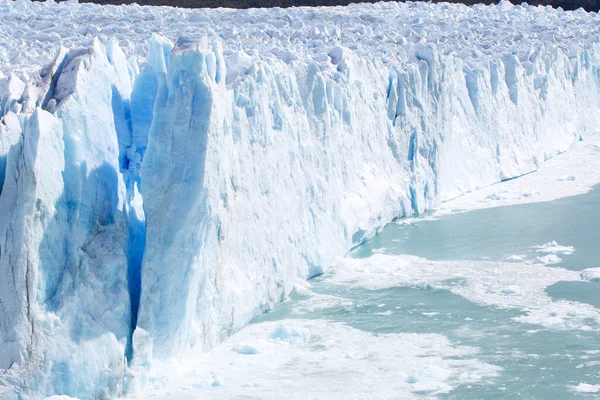 The huge Porito Moreno glacier in Argentina with massive ice carvings smashing into the glacial lake.