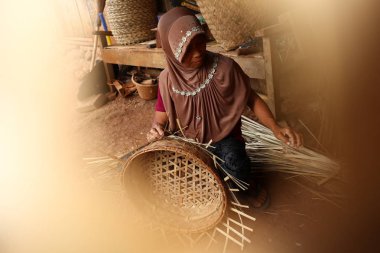 bamboo basket craftswoman while doing his work clipart