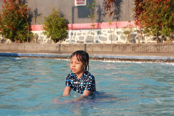 陽気で幸せで高揚感を感じるプールで水遊びをする小さな女の子 — ストック写真