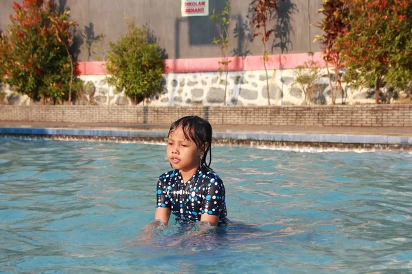 陽気で幸せで高揚感を感じるプールで水遊びをする小さな女の子 — ストック写真