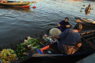 Citra Bahari Barito nehri yüzen pazar sabah, gün doğumundan itibaren altın dolu. Ekonomik faaliyet, tüccarlar Banjarmasin meyve ve sebze satmak / Güney Kalimantan Endonezya