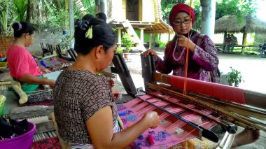 Lombok / Batı Nusa Tenggara-Endonezya'da geleneksel dokuma tezgahları kullanarak kumaş örerken Lombok'ta yaşayanlar, 24 Kasım 2016