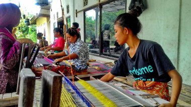 Lombok / Batı Nusa Tenggara-Endonezya'da geleneksel dokuma tezgahları kullanarak kumaş örerken Lombok'ta yaşayanlar, 24 Kasım 2016