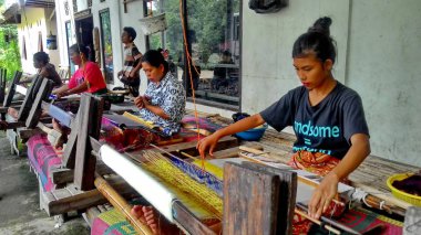 Lombok / Batı Nusa Tenggara-Endonezya'da geleneksel dokuma tezgahları kullanarak kumaş örerken Lombok'ta yaşayanlar, 24 Kasım 2016
