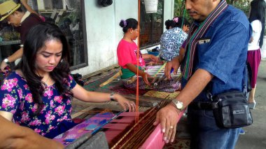 Lombok / Batı Nusa Tenggara-Endonezya'da geleneksel dokuma tezgahları kullanarak kumaş örerken Lombok'ta yaşayanlar, 24 Kasım 2016