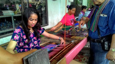 Lombok / Batı Nusa Tenggara-Endonezya'da geleneksel dokuma tezgahları kullanarak kumaş örerken Lombok'ta yaşayanlar, 24 Kasım 2016