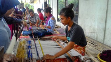 Lombok / Batı Nusa Tenggara-Endonezya'da geleneksel dokuma tezgahları kullanarak kumaş örerken Lombok'ta yaşayanlar, 24 Kasım 2016