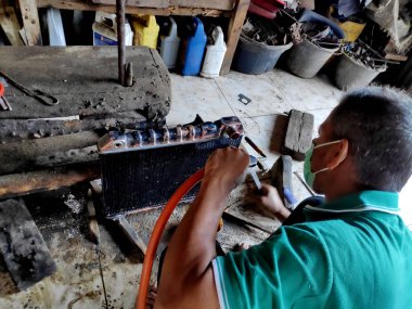 eski arabalarda kırık radyatörleri temizlerken ve tamir ederken radyatör tamircisi. Bir araba atölyesinde, Pekalongan - Jawa Tengah - Endonezya, Haziran 1, 2019