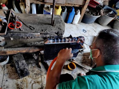eski arabalarda kırık radyatörleri temizlerken ve tamir ederken radyatör tamircisi. Bir araba atölyesinde, Pekalongan - Jawa Tengah - Endonezya, Haziran 1, 2019