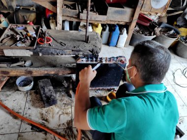 eski arabalarda kırık radyatörleri temizlerken ve tamir ederken radyatör tamircisi. Bir araba atölyesinde, Pekalongan - Jawa Tengah - Endonezya, Haziran 1, 2019