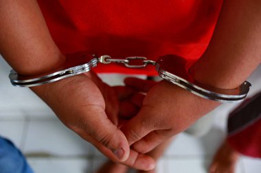   elleri Polis tarafından kelepçelenmiş suçlular