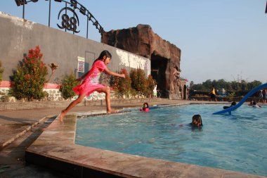 Küçük çocuklar Malang bir çocuk havuzunun turistik alanda neşeyle su oynamak, Doğu Java, Endonezya, Haziran 26, 2019